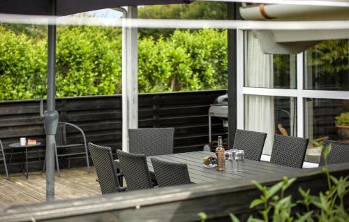 a table with chairs and an umbrella on a patio at Holiday Home Birkemose Ds Dnmk in Skovby