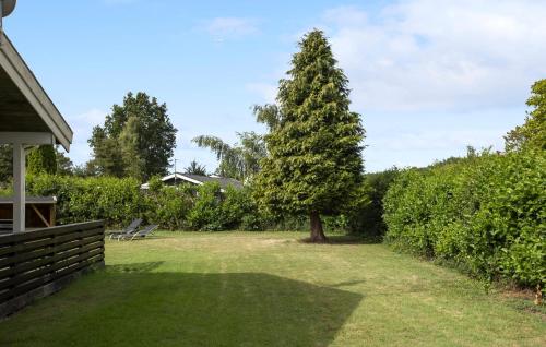 a tree in the yard of a house at Holiday Home Birkemose Ds Dnmk in Skovby