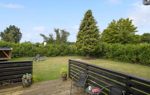 a wooden deck with chairs and a garden at Holiday Home Birkemose Ds Dnmk in Skovby