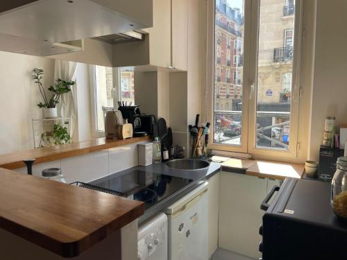 une cuisine avec un évier et un plan de travail dans l'établissement Studio cosy Josy, à Paris