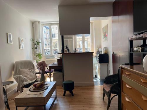un salon avec une table et une cuisine dans l'établissement Studio cosy Josy, à Paris