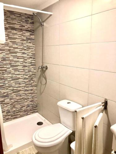 a white bathroom with a toilet and a shower at e5túdio frt in Peniche