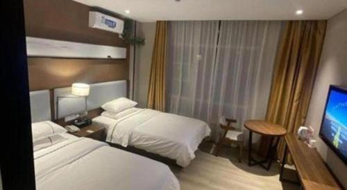 a hotel room with two beds and a flat screen tv at JTOUR Inn Wuhan Textile University in Wuhan