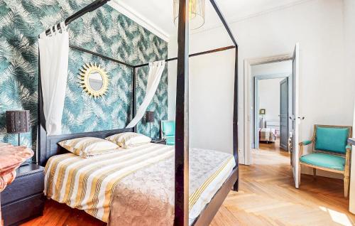 a bedroom with a canopy bed and a blue chair at Awesome Home In Capendu in Capendu