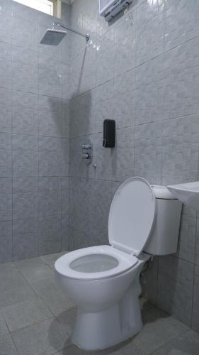 a bathroom with a white toilet and a shower at Villa Dalia Puncak CCC9-26 in Cikujang