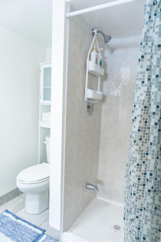 a bathroom with a toilet and a shower at Bright & Spacious 2BR & Parking Near TTC & Shops in Toronto