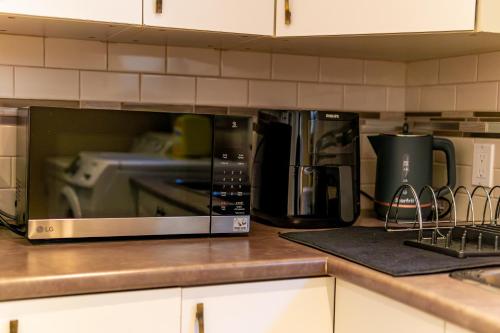a microwave sitting on top of a kitchen counter at Bright & Spacious 2BR & Parking Near TTC & Shops in Toronto