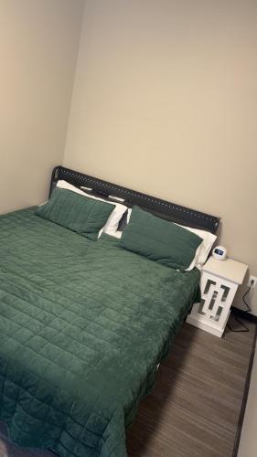 a bedroom with a bed with a green comforter at Willow e-hotel in Mattoon