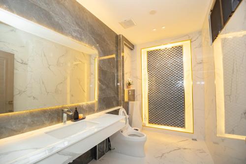 a bathroom with a sink and a toilet and a window at The Swan Pool Villa Hatyai เดอะสวอน พูลวิลล่าหาดใหญ่ in Ban Kohong
