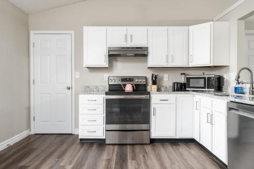 a kitchen with white cabinets and a stove top oven at Peaceful Modern Home near Avon in Avon