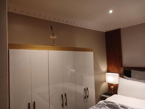 a bedroom with a bed and a white cabinet at Delux Studio apartment in Germiston