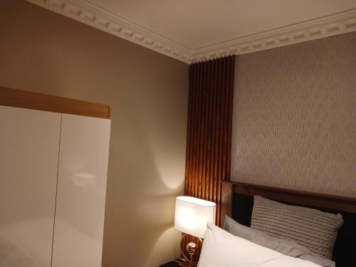 a bedroom with a bed with a lamp next to it at Delux Studio apartment in Germiston