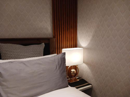 a bedroom with a bed and a lamp on a night stand at Delux Studio apartment in Germiston