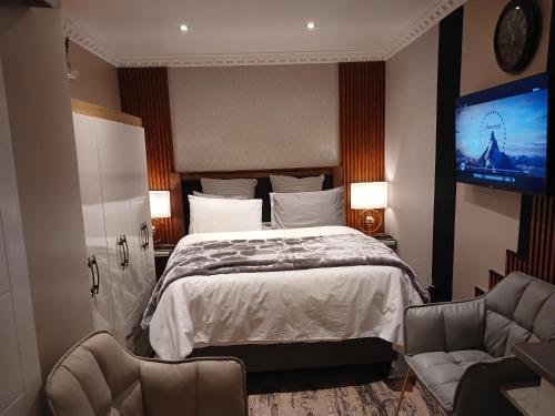 a bedroom with a bed and a flat screen tv at Delux Studio apartment in Germiston