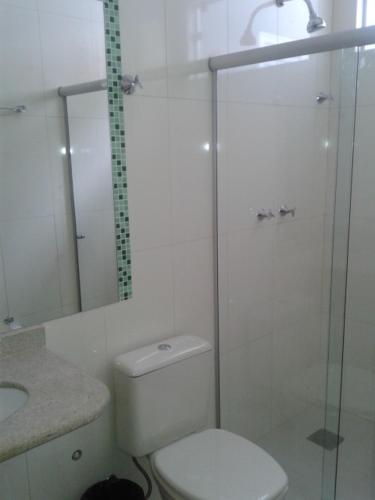 a bathroom with a toilet and a glass shower at Hotel Cristal in Turmalina
