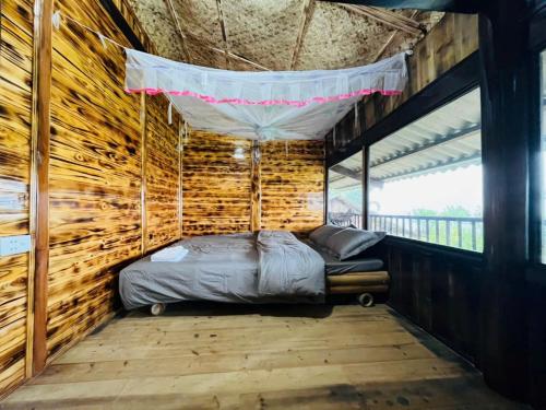 a bedroom in a wooden house with a bed in it at Sapa Guide Homestay & Trekking in Lao Cai