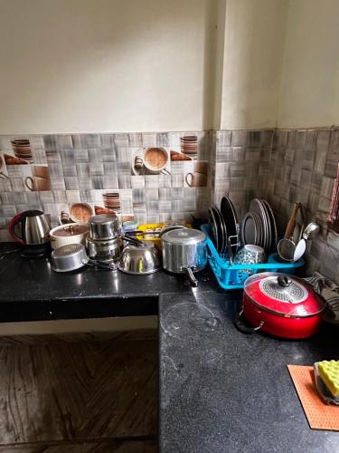 a kitchen counter with pots and pans and dishes at 3 Bhk Air Deck luxury apartment in Patna