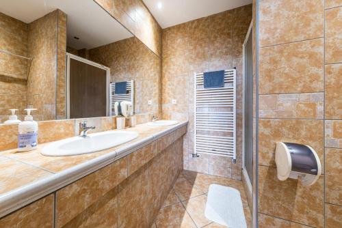 a bathroom with two sinks and a mirror at Penzion Kozí Horka u Brněnské přehrady in Brno