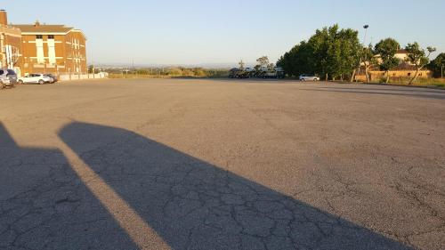 a long shadow of a person on a parking lot at Hotel Reina Isabel in Lleida