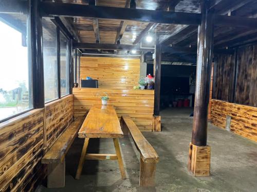 a wooden bench in a room with a wooden wall at Sapa Guide Homestay & Trekking in Lao Cai