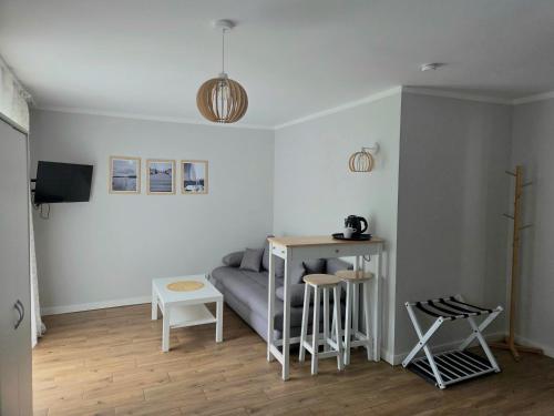 a living room with a couch and a table and stools at Mazurski Kubryk in Ruciane-Nida
