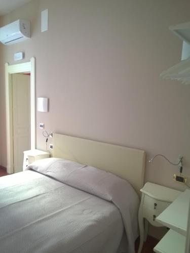 a white bedroom with a bed and a table at B&B Casa D'alleri in Siracusa
