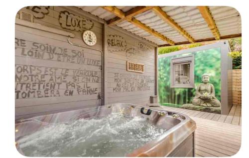 a bathroom with a tub with a statue in it at La chambre du puits avec 2 jacuzzis , sauna et Hammam privatif in Tournai