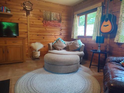 a living room with a couch and a chair and a guitar at The Hideaway in Želiv