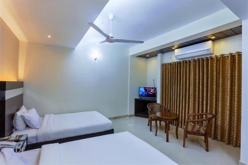 a bedroom with a bed and a table and chairs at Hotel Holy Gate in Sylhet