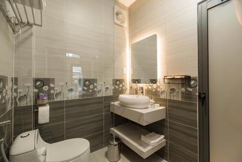 a bathroom with a sink and a toilet and a mirror at Hanhhome in Ho Chi Minh City