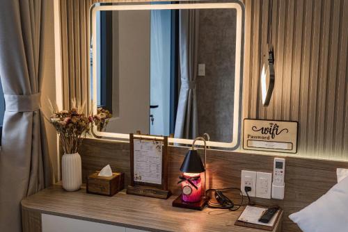 a desk with a lamp and a mirror in a hotel room at Hanhhome in Ho Chi Minh City