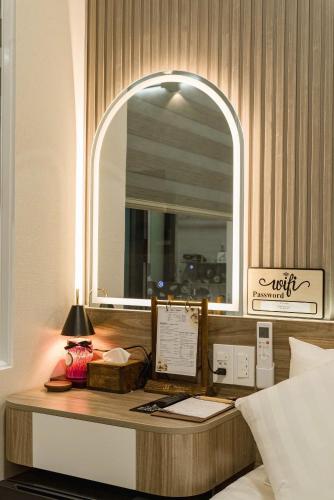 a bedroom with a desk with a mirror and a bed at Hanhhome in Ho Chi Minh City