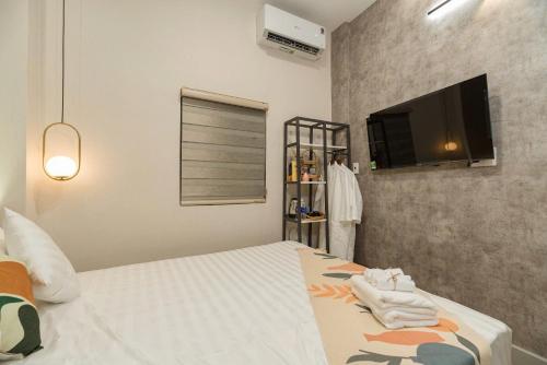 a bedroom with a bed and a flat screen tv at Hanhhome in Ho Chi Minh City