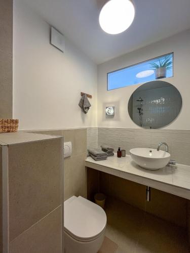 a bathroom with a sink and a toilet and a mirror at Lukenda Rooms - Boutique Apartments with view of Adriatic Sea in Pakoštane