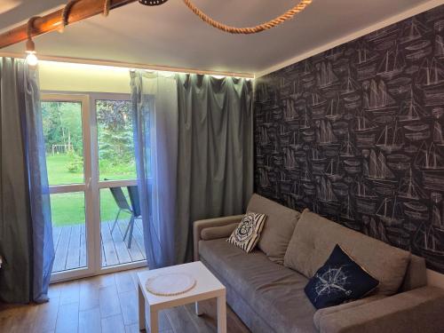 a living room with a couch and a window at Mazurski Kubryk in Ruciane-Nida