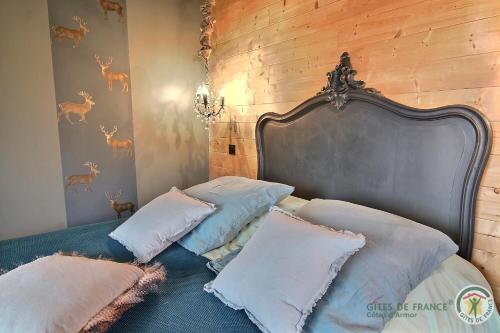 a bedroom with a bed with pillows on it at Chez patricia in Ploubazlanec
