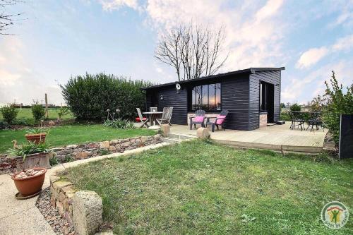 a small black cabin with a patio and a table at Chez patricia in Ploubazlanec