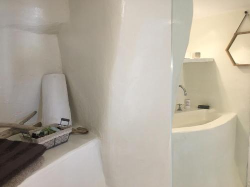 a white bathroom with a sink and a toilet at La Maison de Bella in Lefkes