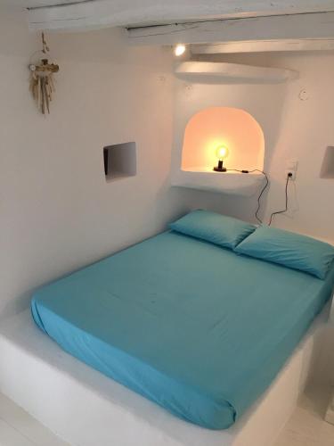 a bed in a white room with a light on it at La Maison de Bella in Lefkes