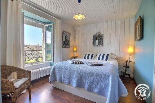a bedroom with a bed and a large window at Le clos des hortensias in Plémy