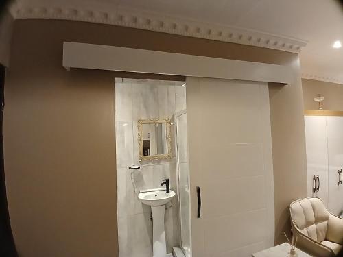 a bathroom with a sink and a mirror at Delux Studio apartment in Germiston