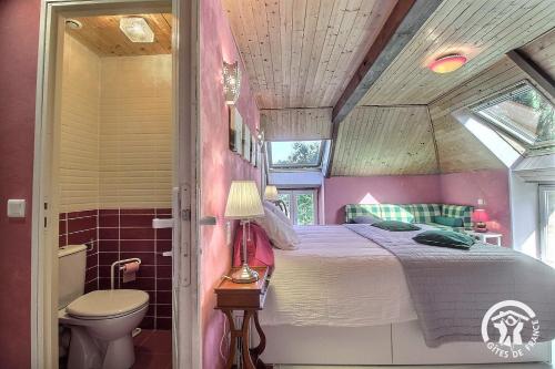 a bedroom with a bed and a toilet in a room at Le clos des hortensias in Plémy