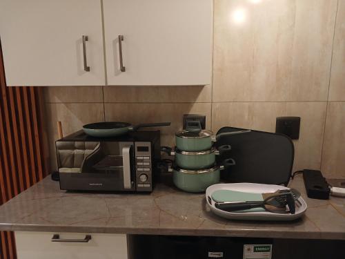 a counter with a coffee maker and a microwave at Delux Studio apartment in Germiston