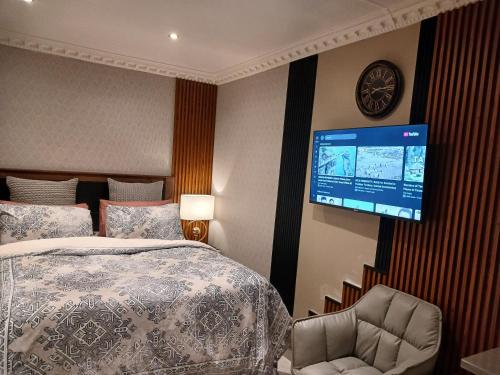 a bedroom with a bed and a tv on the wall at Delux Studio apartment in Germiston