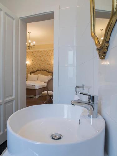 un bagno con lavandino bianco e specchio di Maison Elysée a Sibiu