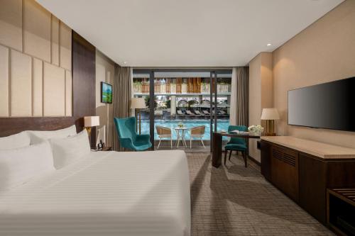 a hotel room with a bed and a flat screen tv at New Orient Hotel Da Nang in Da Nang