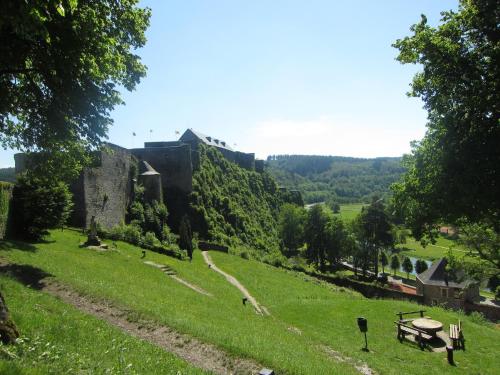 a grassy hill with a castle in the background at Sunny Garden Cottage, Alle in Frahan