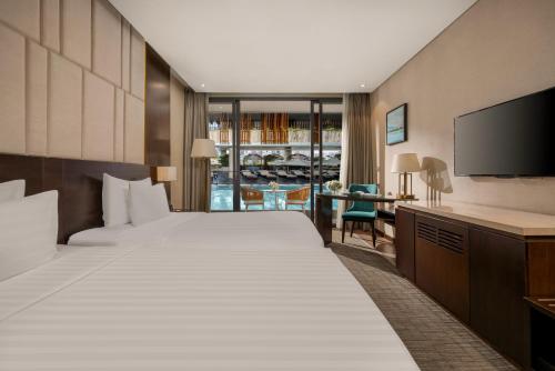 a hotel room with two beds and a flat screen tv at New Orient Hotel Da Nang in Da Nang