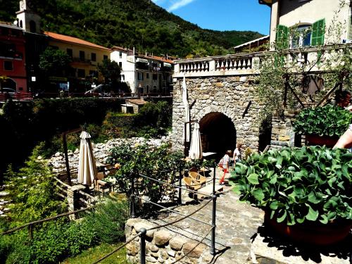 a stone building with an umbrella and some plants at Casa Celestine in Via Orsini Isolabona Liguria Italy Sleeps 5 in Isolabona