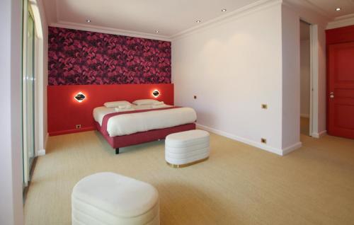 a bedroom with a bed and a red wall at Villa Des Artistes in Suze-la-Rousse